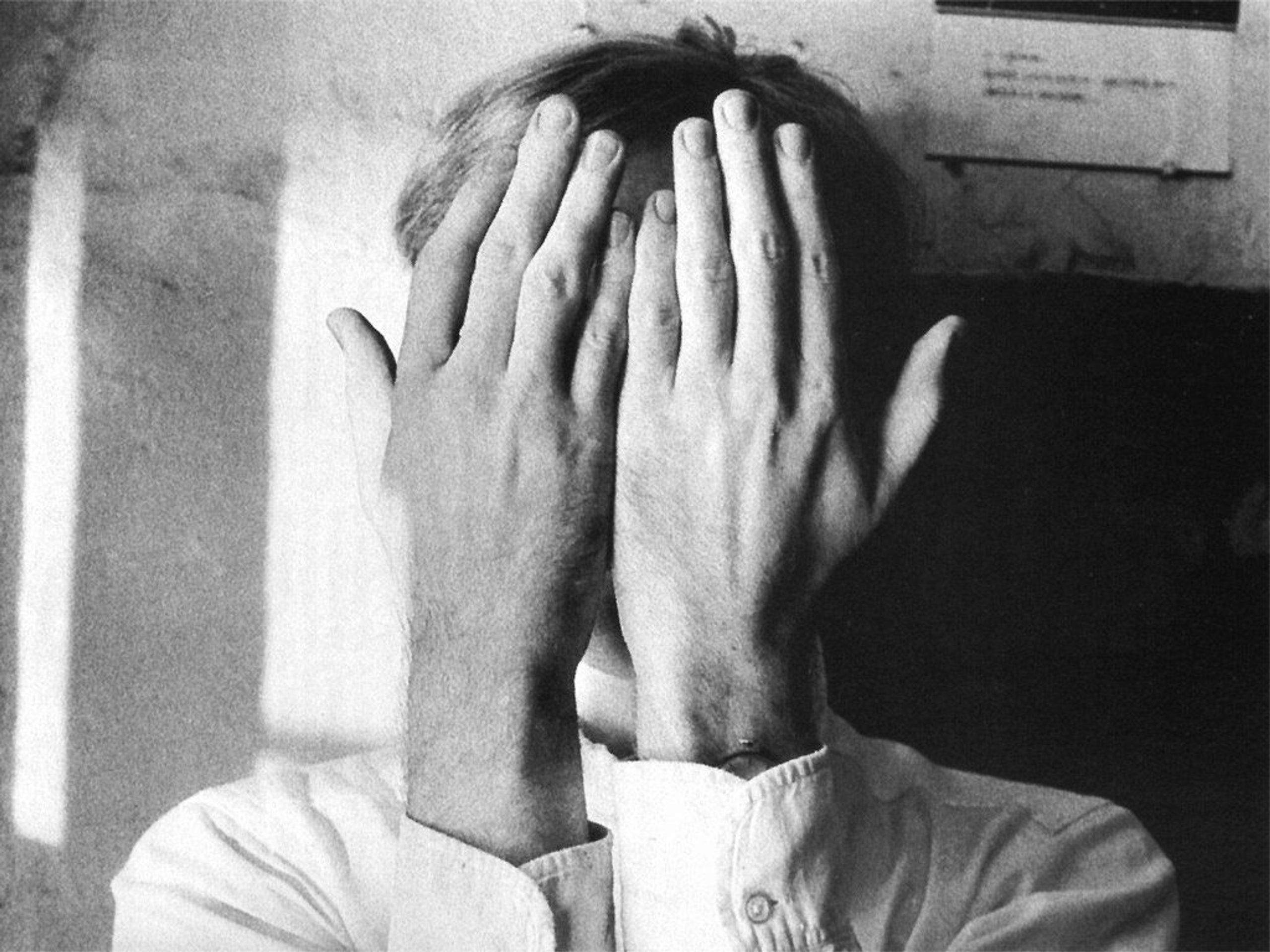 Person with hands over his face, photo by Duane Michals.