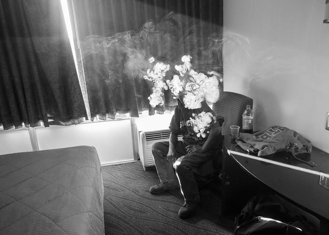Black and white, Bob Mulcahey (50) smokes in his room of the Kings Inn, where Veterans Affairs has placed him temporarily while they address permanent housing for him. Photographer: Todd R Darling