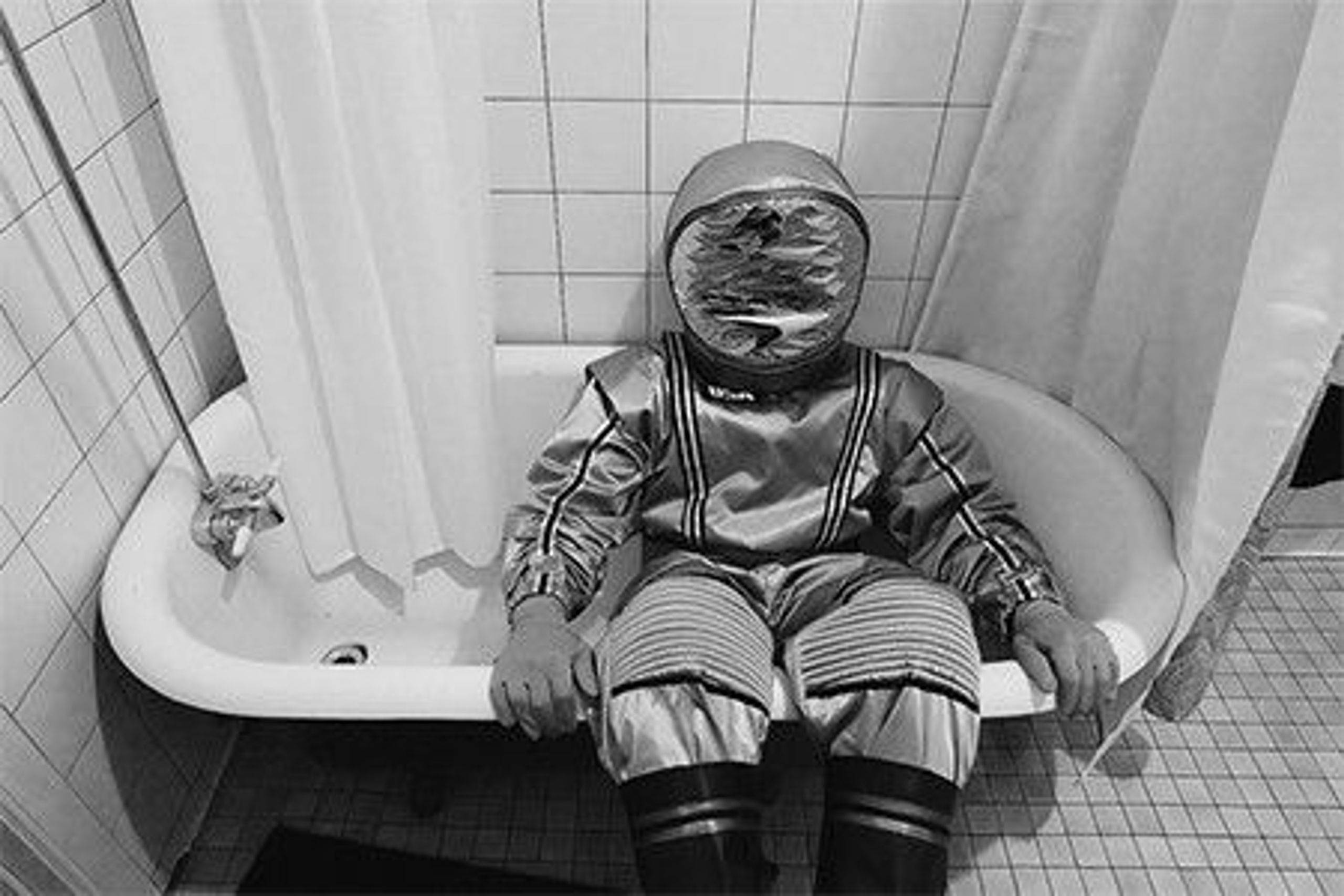 An astronaut sitting in a bath.